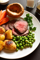 Sunday Roast with roasted beef, carrots, crispy potato, green pea and yorkshire pudding
