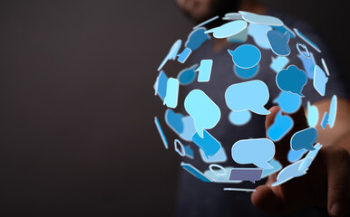 Abstract image of a person's hand interacting with a sphere made of speech bubbles, conveying communication and connection in a digital world.