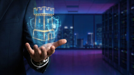 Cybersecurity concept with digital castle and shield hologram floating above hand in data center room at night