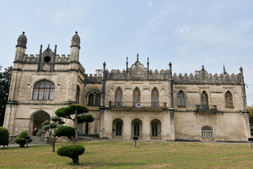 Fototapeta premium Historic castle like building with ornate stonework and towers on a manicured lawn, presenting grand architecture and a medieval atmosphere.