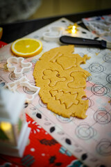 Making Christmas cookies. Cutters, ingredients and raw dough on wooden table, flat lay