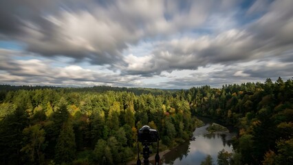 Serene Forest Landscape with River Under Cloudy Sky.