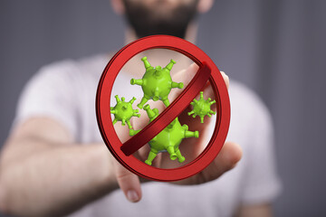 Hand pointing at a stop sign with green coronavirus cells. Concept of preventing the spread of...