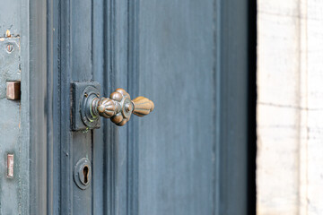 Close-Up of vintage brass door knob on blue wooden door with lock and keyhole detail