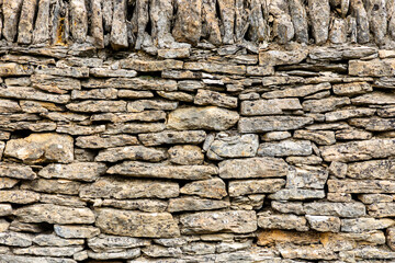 Rugged dry stone wall built from local stone in Cotswold for rustic outdoor setting