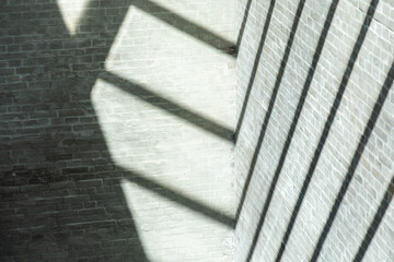 Geometric shadows on brick wall cast by roof construction