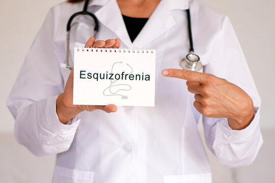 ESQUIZOFRENIA. conceptos medicos y de salud mental. mujer doctor se&ntilde;alando el diagnostico en su libreta