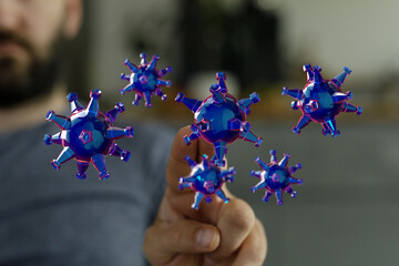 Abstract blue virus models interacting with a hand, symbolizing healthcare, pandemic awareness and scientific