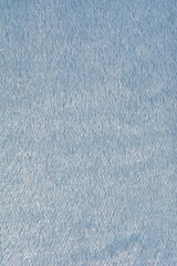 A soft light blue fleece fabric texture is shown in a vertical close up © nahhan