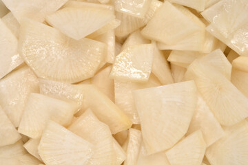 Top down close up of sliced black radish salad pieces in a pile