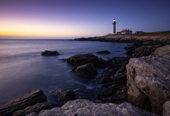 Lighthouse on the Coastline at Dusk with Rocky Shore