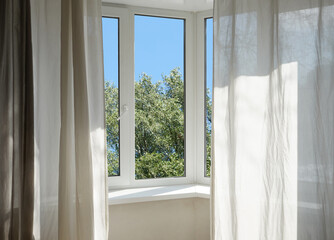 A window overlooking silvery green trees, view from a  panoramic window.