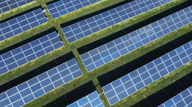 Aerial view of a large solar panel farm generating clean renewable energy, showcasing sustainable power production, green technology, and modern infrastructure for a low-carbon future. 
