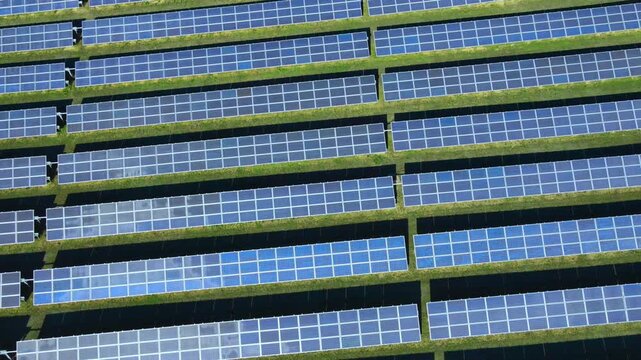 Aerial view of a large solar panel farm generating clean renewable energy, showcasing sustainable power production, green technology, and modern infrastructure for a low-carbon future. 