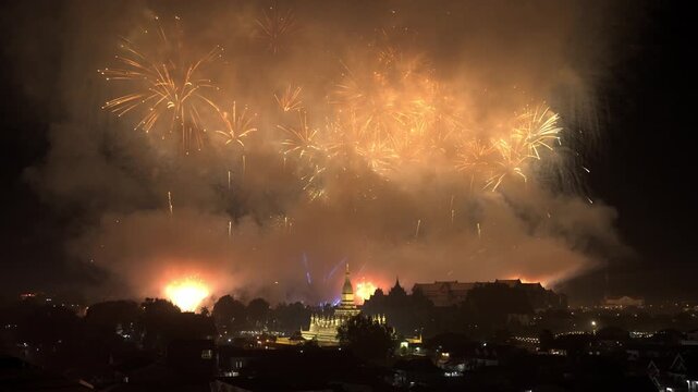 Multi-Color Firework Bursting Above Vientiane's Golden Pha That Luang Stupa at Night during National Celebration
