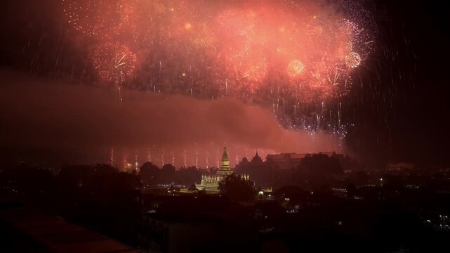 Multi-Color Firework Bursting Above Vientiane's Golden Pha That Luang Stupa at Night during National Celebration