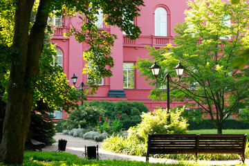 university campus garden bright sunny back yard landscaped space red architecture facade and spring season environment place