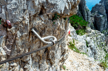 Via ferrata safety cable on steep rocky mountain wall