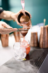 Bartender Using Copper Tools to Pour Red Cocktail