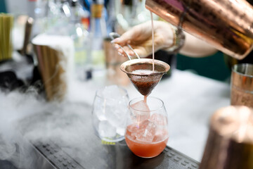 Pink Cocktail Poured Through Strainer with Vapor Effect