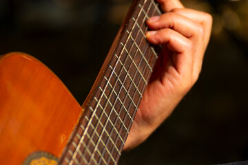 Obraz premium Close Up of Hand Playing Classical Guitar Fretboard The Concept of Music Practice