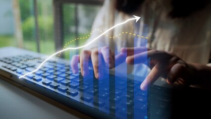 A focused individual typing on a keyboard surrounded by digital data visualizations, illustrating growth and analytics in a modern workplace environment. Copula