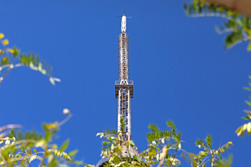 Mhaismal, MH, India, Dec 12: View of the concrete Doordarshan TV transmission tower and antenna, prominently set against a deep blue sky and framed by the tops of dry, scattered trees.