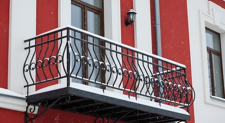 Ornate Wrought Iron Balcony on a Red and White Building Facade.