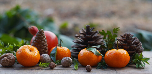 Tangerines and fir nuts on a board