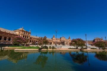 Obraz premium Sevilla, Spain - August 01, 2024: The famous Plaza de España, a plaza in the Parque de María Luisa in Seville built in 1928 in a mix of architectural elements.