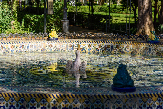 Sevilla, Spain - August 01, 2024: Fuente de las Ranas (Fountain of the Frogs), a distinctive water feature located in the Parque de Mar&iacute;a Luisa in Seville, Spain. 
