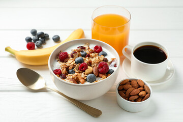 Healthy breakfast. Oatmeal with nuts, berries and milk on white wooden table, closeup