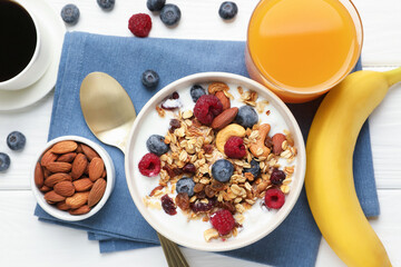 Healthy breakfast. Oatmeal with nuts, berries and milk served on white wooden table, flat lay