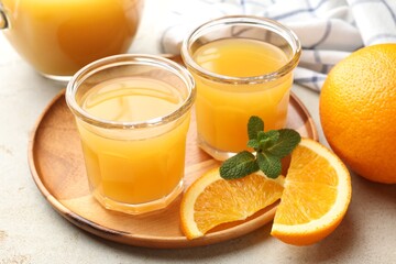 Fresh orange juice, mint and fruits on light table, closeup