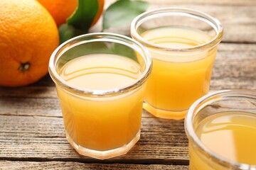 Fresh orange juice and fruits on wooden table, closeup