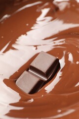 Tasty melted chocolate and piece as background, closeup