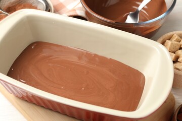 Liquid chocolate dough, cocoa powder and brown sugar on table, closeup