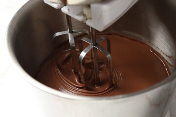 Mixing chocolate dough in bowl, closeup view