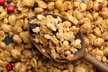 Tasty granola with dried fruits and spoon on table, top view