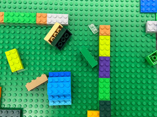 Fototapeta premium Colorful lego bricks on green base plate
