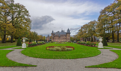 Beautifully landscaped formal garden of Castle De Haar. Manicured lawns, colorful flower beds, and the medieval fortress view in Utrecht.