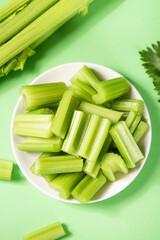 Fresh green cut celery on green background
