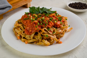 Pasta spaghetti with tomato sauce in white plate on white textured background, Italian food concept