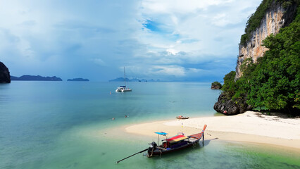 Fototapeta premium Vacation in Thailand. Relaxing at sea, tourists on the shores of Rai Island, flying above people. Relaxing on a sandy beach by the sea.
