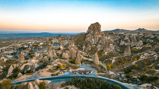 Cappadocia, Goreme, is revealed from a drone view showing fairy chimneys, carved valleys, ancient cave dwellings, and layered volcanic rock formations shaping the landscape from above.
