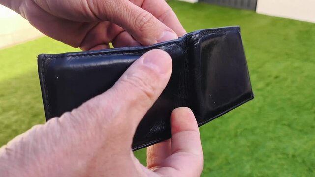 Hands opening an empty wallet with no money &ndash; financial crisis and poverty concept