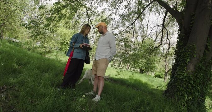 Couple Sharing Cake with Their Dog in the Park: A Heartwarming Scene of Love and Togetherness Under a Tree