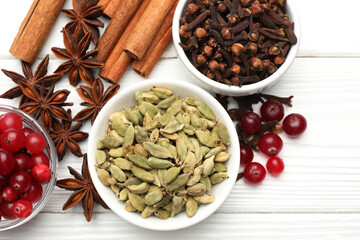 Different spices and cranberries for mulled wine on white wooden table, flat lay