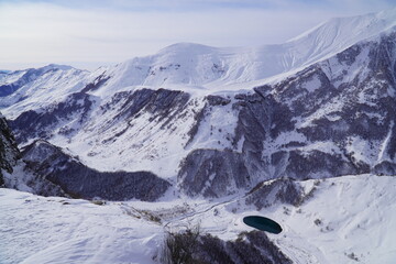 A snow-covered mountain range in the Caucasus region near the Gudauri ski resort. Georgia. Snow-capped mountain peaks and steep slopes.