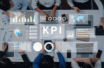 A diverse team engaged in a business meeting focused on analyzing key performance indicators through various charts and metrics to enhance strategic decision-making. Gantry